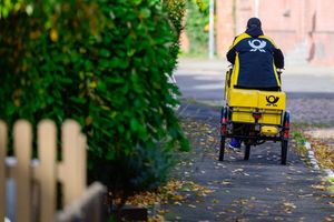 Ein Briefträger bei der Arbeit. - Foto: Philipp Schulze/dpa