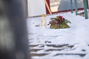 Vor dem Firmengebäude, in dem die Leichen der beiden Söhne gefunden wurden, liegen eine Kerze und ein Kranz. - Foto: Jason Tschepljakow/dpa