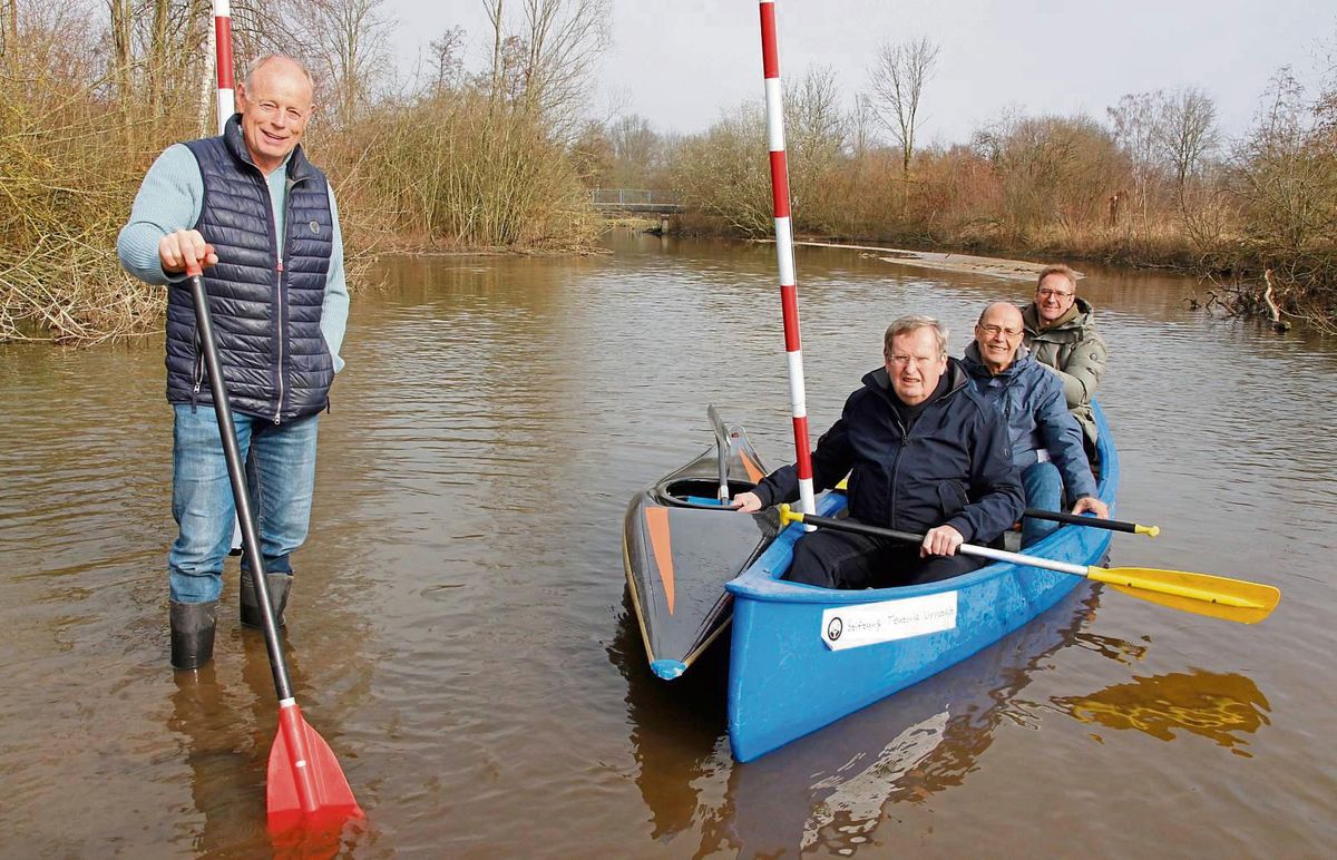 Kanu-Ass Bernd Deppe (l.) kann im ersten Slalomtor am Bootshaus in Gummistiefeln stehen – soviel Sand hat das Hochwasser in den Lippe-Arm geschwemmt. Angler-Chef Klaus Laufkötter, Gewässerwart Kurt Rummel und WSC-Vize Rainer Staats laufen derweil im Boot (v.l.) auf Grund. Im Hintergrund rechts ist aus dieser Perspektive schon gut die erste Sandbank auszumachen. Alle sagen: „Der Sand muss weg.“ Foto: Niggenaber