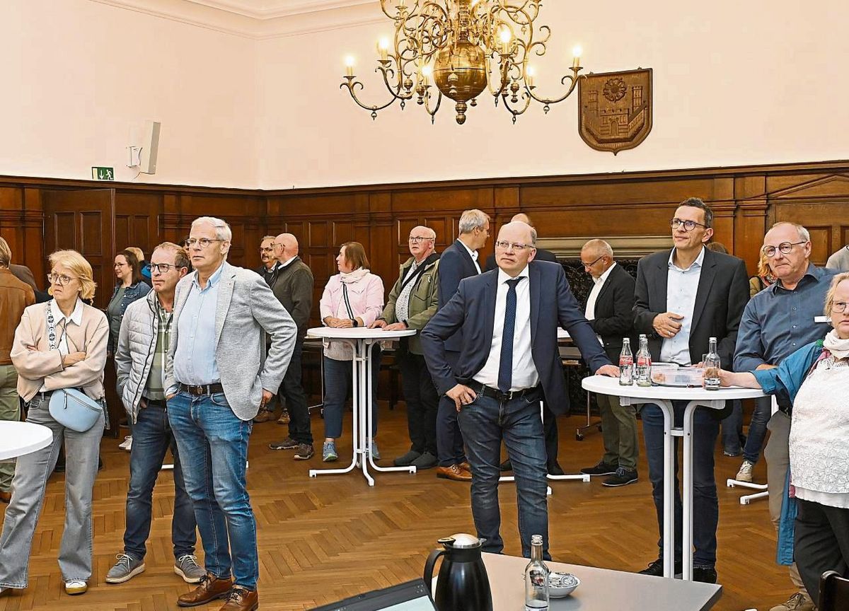 Gebannte Blicke auf den Monitor: Politiker, Verwaltungsmitarbeiter und interessierte Bürger verfolgten die Ergebnis-Präsentation im Rathaussaal. Stephan Tydecks (4.v.r) führte als Wahlleiter durch den Abend. Foto: Dieter Tuschen