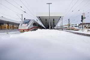 Zwei ICE stehen im verschneiten Hauptbahnhof Hannover. - Foto: Moritz Frankenberg/dpa
