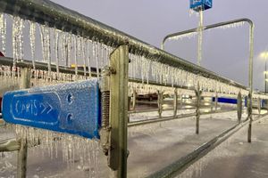 Eiszapfen hängen an einem Geländer während eines Wintersturms auf einem Parkplatz. - Foto: John Raby/AP/dpa