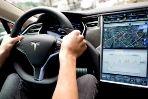 Ein Mann sitzt in einem Tesla Model S am Lenkrad: Elon Musk sagt, er sei mit seinen Versprechen zu selbstfahrenden Autos oft zu optimistisch gewesen. - Foto: Sven Hoppe/dpa