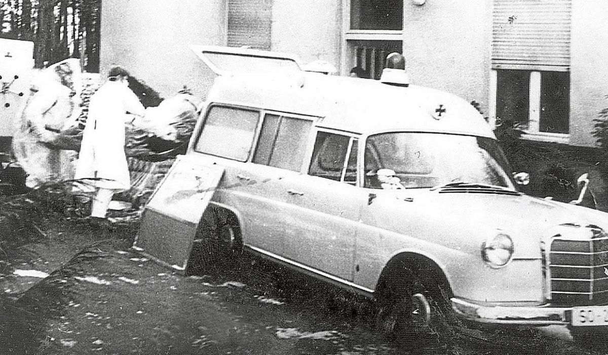 Ein Opfer der Pockenepidemie von 1970 in Meschede wird auf diesem undatierten Archivbild von 1970 von Helfern mit Mund- und Atemschutz in einen Krankenwagen verladen. Foto: dpa