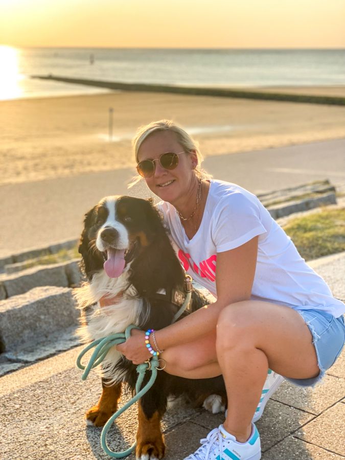 Verena Grube und ihr Berner Sennenhund Hermann genießen den Sonnenuntergang auf Norderney.