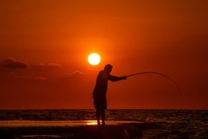 Alltag im Libanon: Ein Fischer wirft seine Angel von einem felsigen Gebiet entlang der Küste von Beirut aus, während die Sonne über dem Mittelmeer untergeht. - Foto: Hassan Ammar/AP/dpa