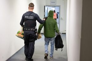Ein Polizeibeamter bringt einen Mann zu einem Abschiebeflug nach Pakistan. (Archivfoto) - Foto: Boris Roessler/dpa
