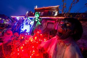 Gruselige Figuren stehen in Mettmann vor einem beleuchteten Halloween-Haus. - Foto: Henning Kaiser/dpa