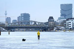 Ein Mann steht am Treptower Park in Berlin auf der zugefrorenen Spree. - Foto: Elisa Schu/dpa
