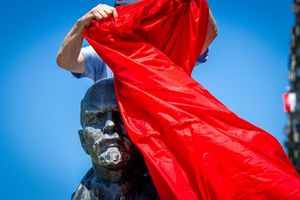Vertreter von Opferverbänden verhüllen bei einer Kundgebung in Schwerin eines der letzten Lenin-Denkmäler in Deutschland und protestieren damit gegen die öffentlichen Ehrungen der Repräsentanten von Systemen der Gewaltherrschaft. - Foto: Jens Büttner/dpa
