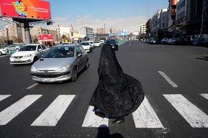 Alltag in Teheran: Verschleierte Frau überquert Kreuzung im Zentrum - Foto: Vahid Salemi/AP/dpa
