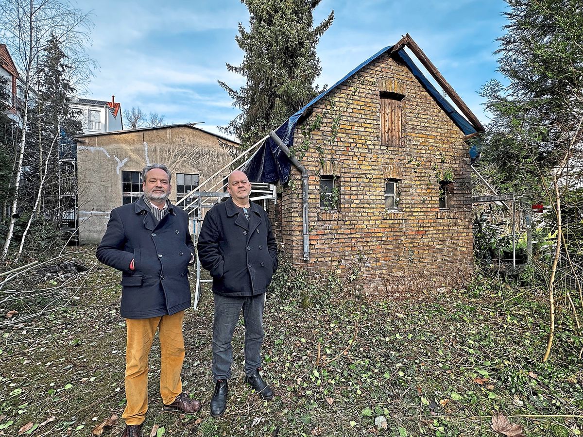 Hinter dichtem Efeu versteckte sich die Tür zum Dachboden des Gartenhauses der Synagoge: Dort entdeckten Handwerker bei der Dachsanierung die Buch-Fragmente. Professor Dr. Jürgen Overhoff (l.) und Dirk Raulf freuen sich über die wichtigen Spuren jüdischen Lebens.