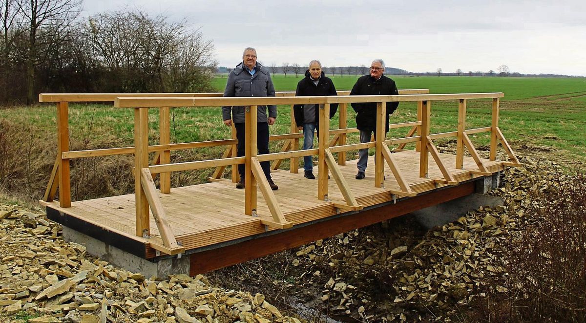 Sie präsentieren die neue Brücke über dem Fangegraben (v.l.): Ortsvorsteher Alfons Levenig und die Vorsitzenden des Vereins Heimatfreunde Oestereiden Robert Kußmann und Georg Eickhoff. Fotos: Mintert
