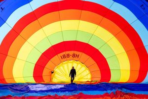 Ein Teammitglied überprüft seinen Heißluftballon vor dem Start während des 46. Internationalen Heißluftballon-Festivals in Chateau-d'Oex. - Foto: Cyril Zingaro/KEYSTONE/dpa