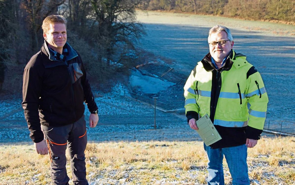 Auf dem Damm des Rückhaltebeckens Eringerfeld erklären (v.l.) Johannes Schäfers und Martin Lehmann vom Wasserverband Obere Lippe dessen Funktion. Dahinter die Westernschledde, bevor sie den Damm durchfließt. Foto: Kossack