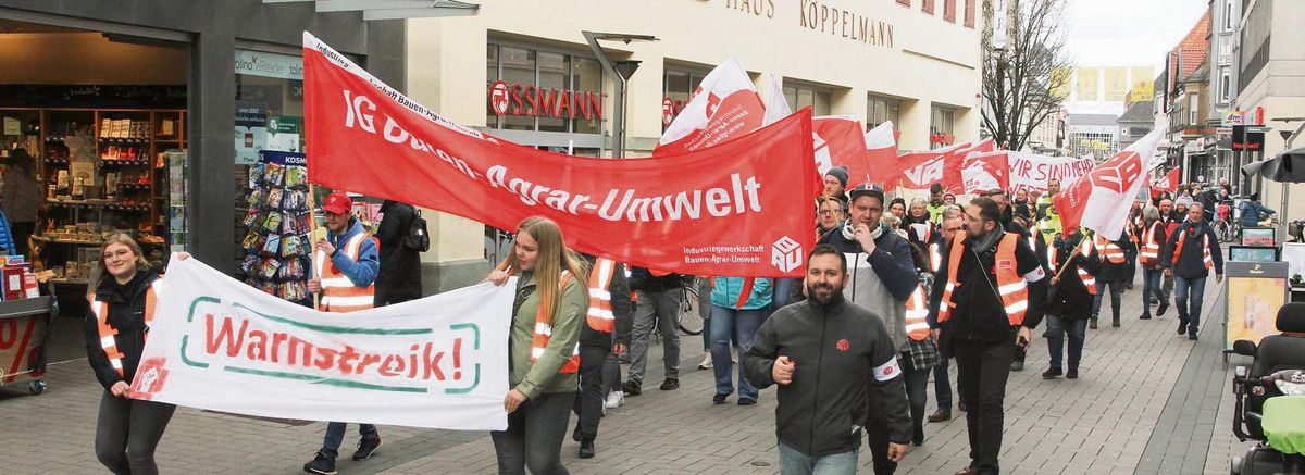 Mit Transparenten und Trillerpfeifen folgten Beschäftigte der Deutschen Saatveredelung dem Warnstreik-Aufruf der IG Bau, hier mit Gewerkschaftssekretär Lukas Rittinghaus (vorne r.) an der Spitze. Durch die Lange Straße in Lippstadt ging es zum Firmensitz. Foto: Schwade