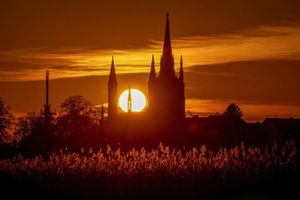 Hinter der Heilig-Geist-Kirche auf der Insel Werder geht die Sonne unter. - Foto: Georg-Friedrich Moritz/dpa