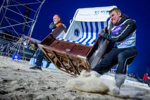 Sie geben alles: Das Team „Quad Safari Usedom“ mit Phillip Schmidt (l) und Finley Liemen (r) gewinnt den Finallauf bei der 18. Strandkorb Weltmeisterschaft auf der Insel Usedom mit einer neuen Weltrekordzeit von 4,56 Sekunden. Die Zweierteams müssen bei dem Wettkampf einen etwa 60 Kilogramm schweren Strandkorb über die 20 Meter lange Strecke über den Ostseestrand ins Ziel schleppen. - Foto: Jens Büttner/dpa