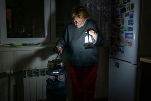 Eine Mutter kocht auf einem Gasbrenner nach einem Stromausfall in Kiew durch einen russischen Angriff. - Foto: Dan Bashakov/AP/dpa