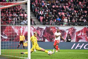 Bremens Torwart Mio Backhaus (l, Werder Bremen) und Ridle Baku (RB Leipzig) schauen dem Ball hinterher. Backhaus verhinderte mit seinen Paraden einen frühen Rückstand der Gäste in Leipzig. - Foto: Jennifer Brückner/dpa