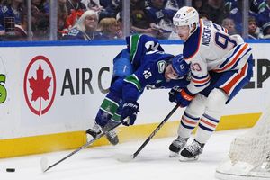Quinn Hughes von den Vancouver Canucks wird von Ryan Nugent-Hopkins von den Edmonton Oilers zu Fall gebracht. - Foto: Darryl Dyck/The Canadian Press via AP/dpa