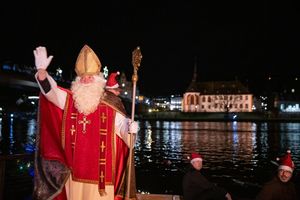 Von zahlreichen Fackelschwimmern begleitet ist der Nikolaus in Bernkastel-Kues in einem Ruderboot über die Mosel gekommen. - Foto: Harald Tittel/dpa