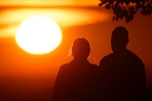 Ein Paar bei Sonnenaufgang - Foto: Julian Stratenschulte/dpa