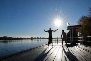 Zwei junge Männer haben Spaß beim Eisbaden in Hamburg an der Alster. - Foto: Christian Charisius/dpa