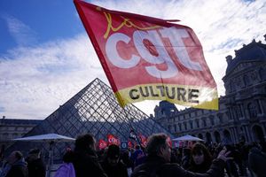 Angestellte zeigen eine Flagge der Gewerkschaft CGT vor dem Louvre, nachdem sie für einen Streik gestimmt haben. - Foto: Michel Euler/AP/dpa