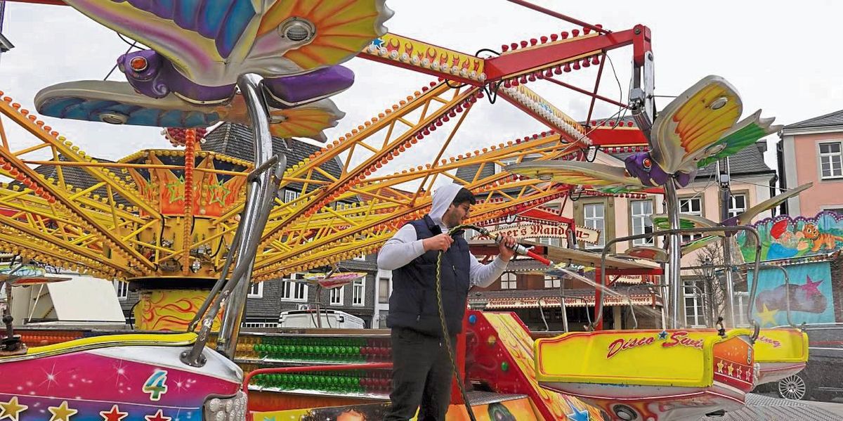 Mit Hochdruck auf blitzblank: Mitarbeiter Shako spritzt die Gondeln vom Twister-Karussell „Disco Swing“ ab. Foto: Vielberg
