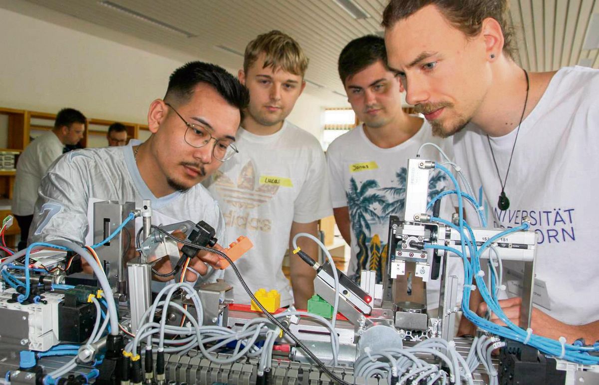 Die hellgrünen Würfel ins Töpfchen, die anderen ins Kröpfchen: Wie die schwarze KI-Kamera für dieses Vorhaben geschult werden kann, lernten jetzt Industrie- und Werkzeugmechaniker in einer Praxisprobe der Uni Paderborn. Foto: Schwade