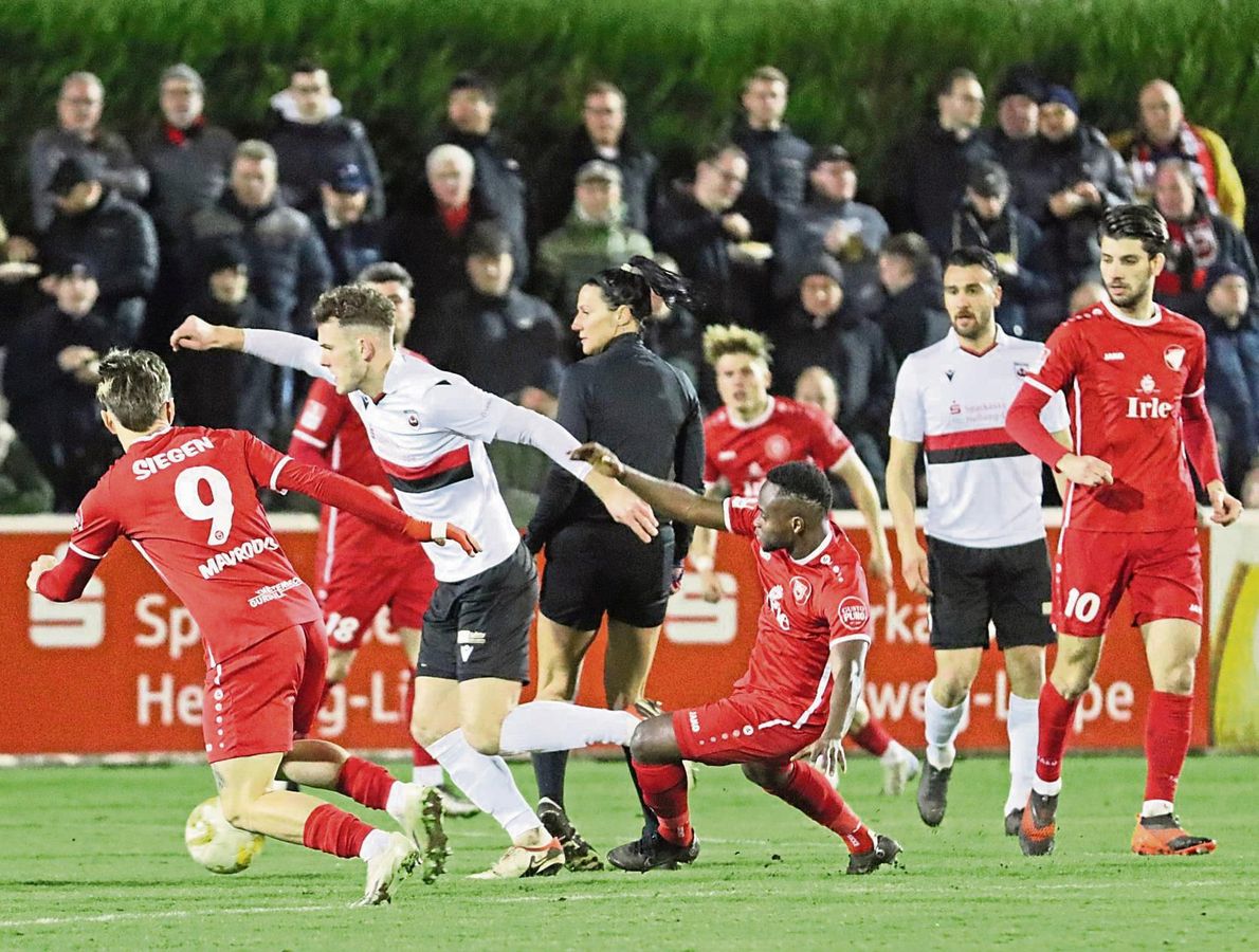 Die Sportfreunde Siegen waren gestern im Topspiel nicht nur deutlich besser, sondern meistens auch in Überzahl. In dieser Szene kämpfen sich die Lippstädter Janik Steringer (l.) und Hasan Dere (r.) durch die dicht gestaffelten Reihen der Gäste. Fotos: Lütkehaus