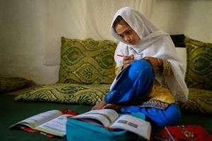 Die zehnjährige Hajira aus der afghanischen Provinz Nangarhar sitzt in einem Haus in einem abgelegenen Dorf östlich von Kabul über Schulbüchern und lernt. - Foto: Elise Blanchard/Unicef/dpa