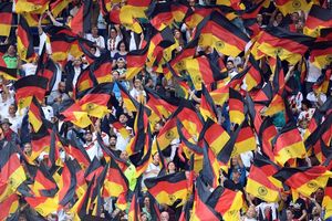 Fans schwenken Deutschlandfahnen auf der Tribüne. - Foto: Uli Deck/dpa