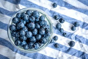 Beeren statt Chips oder Nüsschen: Heidelbeeren, auch Blaubeeren genannt, liegen auf einem Esstisch und werden gern gesnackt. - Foto: Sina Schuldt/dpa