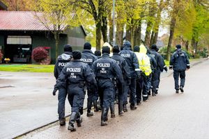 Polizisten gehen auf der Suche nach einem vermissten Jungen durch eine Ortschaft in Niedersachsen. - Foto: Daniel Bockwoldt/dpa