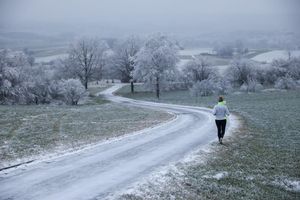 Joggerin trotzt Schnee und Raureif an Heiligabend in Uttenweiler - Foto: Thomas Warnack/dpa