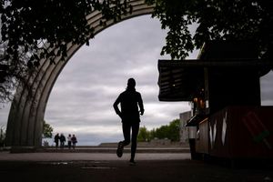 Ein Stück Alltag: Ein Mann joggt am Freiheitsbogen des ukrainischen Volkes in Kiew. - Foto: Francisco Seco/AP/dpa