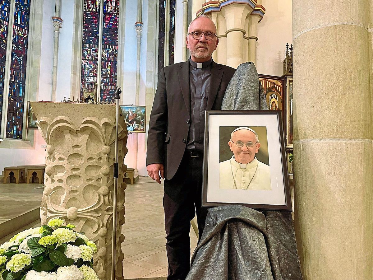 Pastor Thomas Wulf vor dem Portrait des verstorbenen Papstes in der Nikolaikirche. Um das Wirken des Heilligen Vaters trefflich zusammenzufassen, gefällt Wulf besonders ein Ausspruch von Bischof Heinrich Timmerevers, der sagte: 