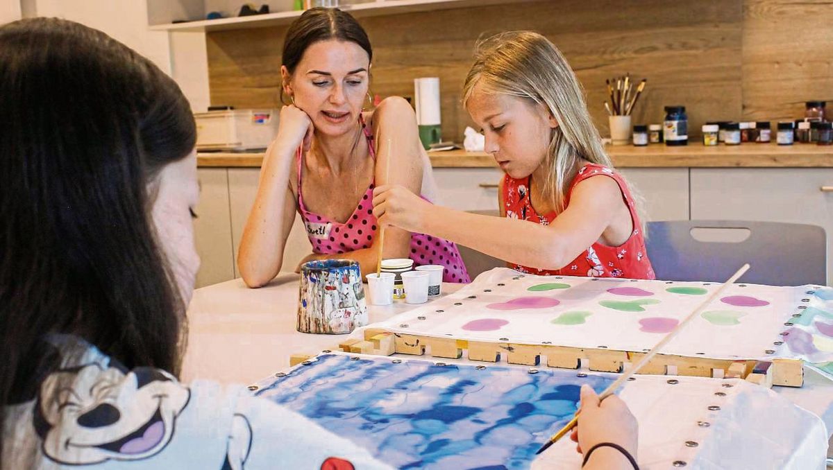 Swetlana Ritter erklärt Ida, welche Farben sie für ihr sommerliches Seidentuch benutzen kann. Foto: N. Wissing