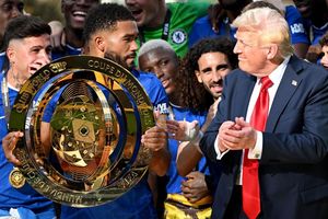 Chelseas Kapitän Reece James (l/vorn) hält auf dem Siegerpodest die Trophäe in den Händen und schaut irritiert zu US-Präsident Donald Trump. - Foto: Sven Hoppe/dpa