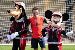 Thomas Müller mit Goofy und Micky Maus. - Foto: Sven Hoppe/dpa