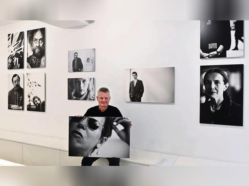 Stefan Worring zeigt seine Porträts in der Pop-up-Galerie. In Händen hält er ein Bild der Regisseurin Doris Dörrie. Foto: Tuschen