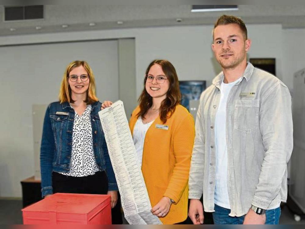 Das Wahlamt im Stadthaus hat geöffnet (v.l.): Anja Erlenkötter, Johanna Druffel und Justin Benkel vom Fachdienst Organisation präsentieren die rote Briefwahlurne.