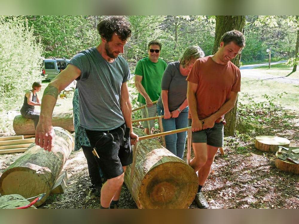 Teamwork: Zu sechst tragen die Kursteilnehmer eine Klotzbeute in den Schatten.