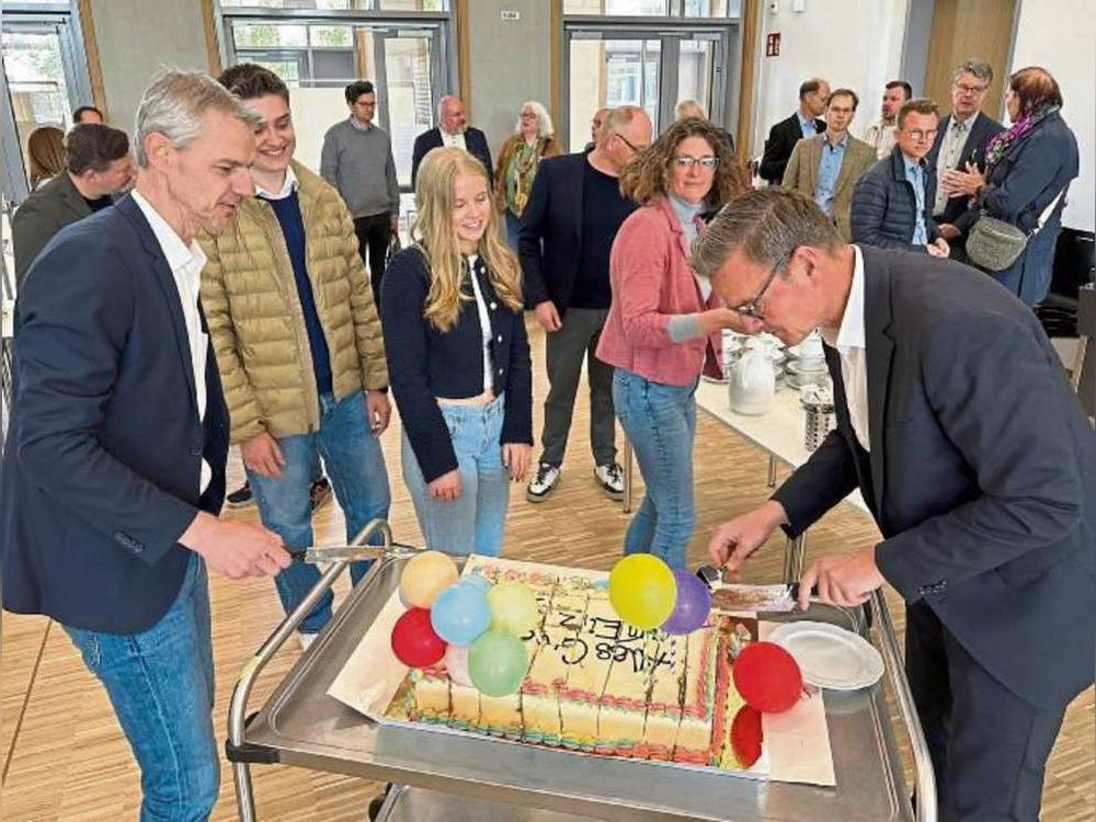 Eine Torte zum Einzug: Schulleiter Matthias Stolper (l.) und Bürgermeister Andreas Sunder kümmerten sich nach dem Durchtrennen des roten Bandes auch um die Bewirtung der Gäste.