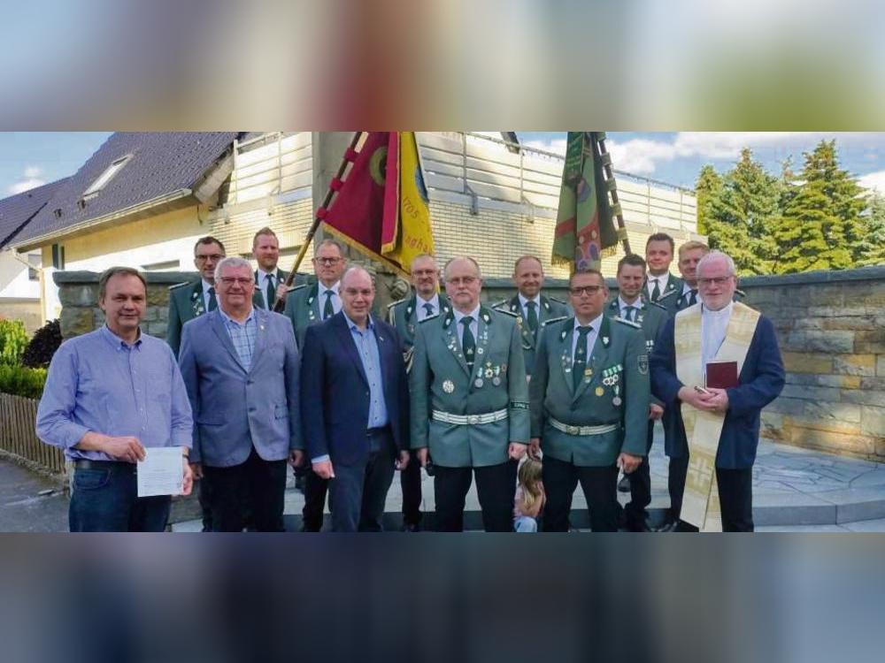 Freuen sich über die Sanierung von Ehrenmal und Fahnen (vorne v.l.): Ortsvorsteher Robert Oesterhoff, Alfons Levenig (Leader Verbund), Bürgermeister Peter Weiken, Ehrenvorsitzender Karl-Josef Beiteke, Vorsitzender Markus Schulze, Pastor Stefan Gosmann sowie der Vorstand der St. Nikolaus Schützenbruderschaft (hintere Reihe). Foto: Thomas