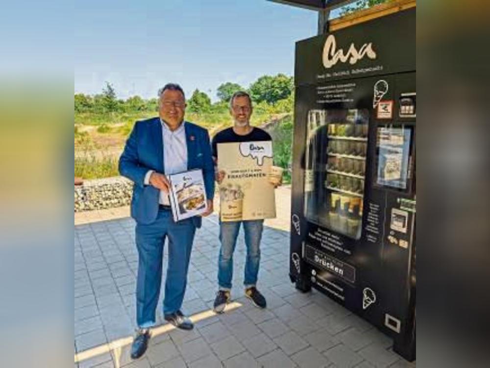 Coole Erfrischung: Bürgermeister Christian Thegelkamp (l.) und Grischa Michel (Casa GmbH) haben den neuen Eisautomat direkt ausprobiert.