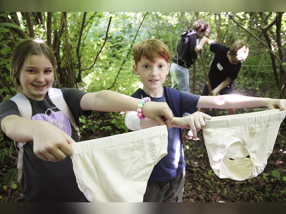 Hannah Hartmann und Hannes Kristmann bringen zusammen mit ihren Mitschülern, die im Hintergrund fleißig buddeln, die Unterhosen unter die Erden. Fotos: Puls
