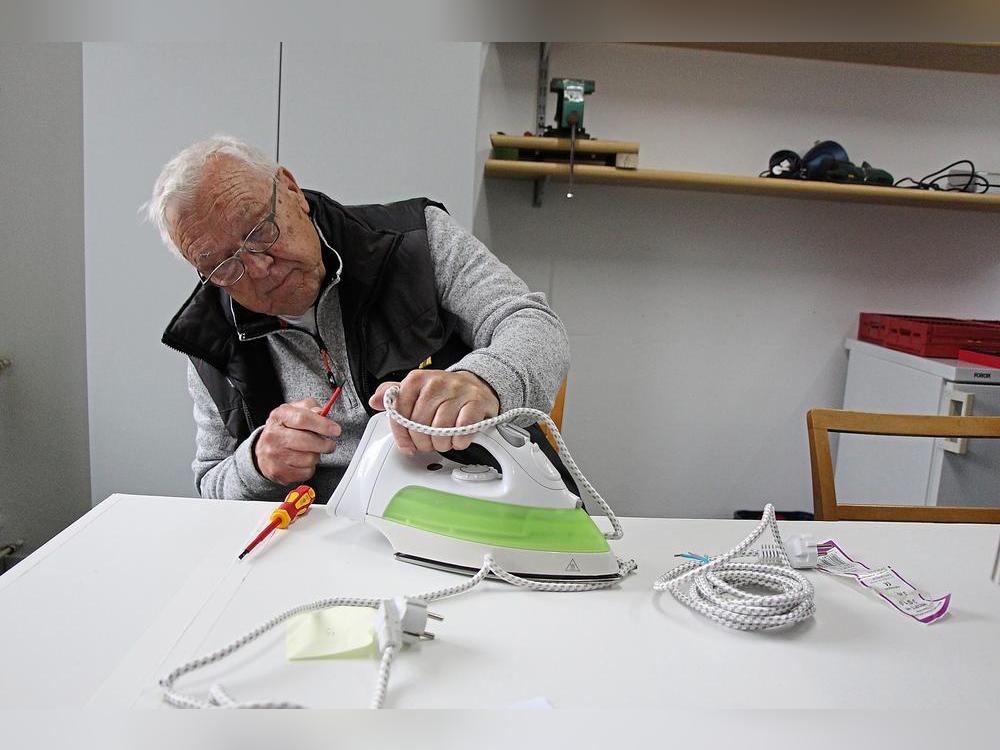 Gar nicht so einfach: Manfred Nölle tauscht das Kabel eines Bügeleisens. Foto: Löseke